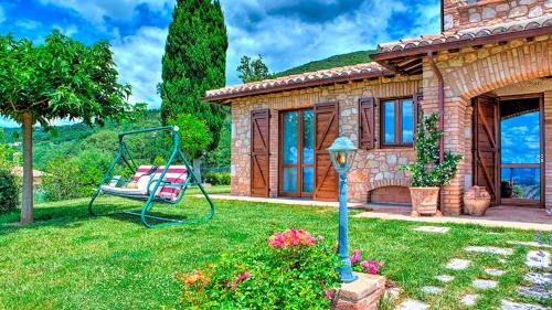 a house with a swing in the yard at Villa Bella 8, Emma Villas in Massa Martana