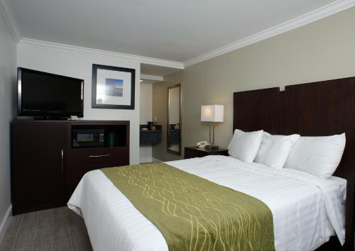 a hotel room with a bed and a flat screen tv at Hi View Inn & Suites in Manhattan Beach
