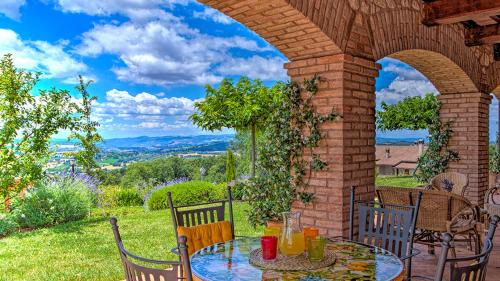 a patio with a table and chairs and an archway at Villa Bella 8, Emma Villas in Massa Martana