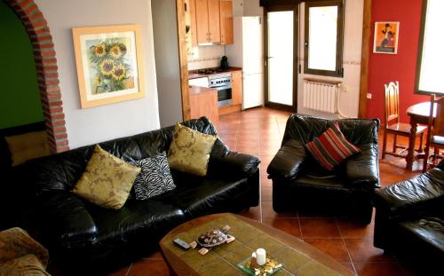 a living room with two leather couches and a table at Suite Rural Carenas in Carenas