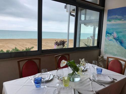 a table in a restaurant with a view of the beach at Da Mariolino in Numana