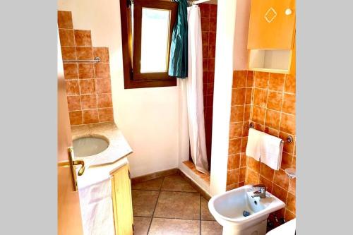 a small bathroom with a sink and a toilet at Sunrise 23 in San Pantaleo