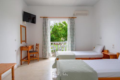 a hotel room with two beds and a window at Zante Apts in Laganas