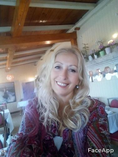 a woman with long blonde hair sitting in a restaurant at Da Mariolino in Numana