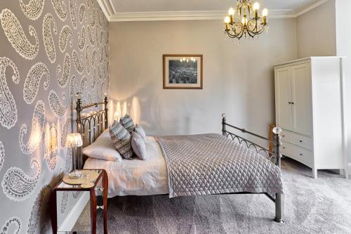 a bedroom with a bed and a chandelier at Sefton Court in Llandudno
