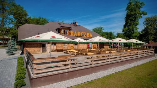 a restaurant with tables and chairs in front of a building at Sport Rooms Spała in Spała