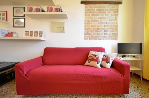 a red couch with two pillows on it in a living room at MORI get-by-train in Venice