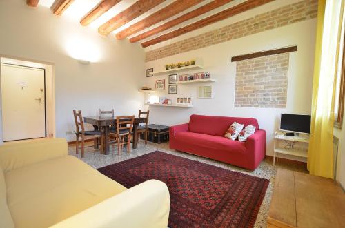 a living room with a red couch and a table at MORI get-by-train in Venice
