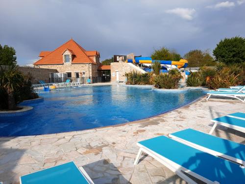 une piscine avec des chaises et un parc aquatique dans l'établissement Location mobil home, à La Baule