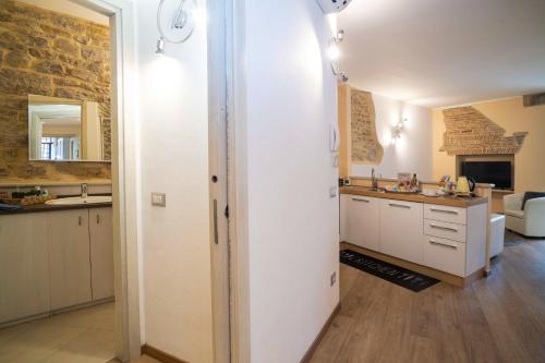 uma cozinha com armários brancos e uma parede de tijolos em Colleoni 20 em Bérgamo