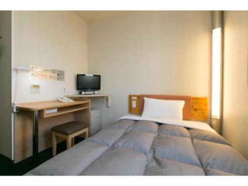 een slaapkamer met een bed en een bureau met een computer bij R&B Hotel Nagoya Nishiki - Vacation STAY 15165v in Nagoya