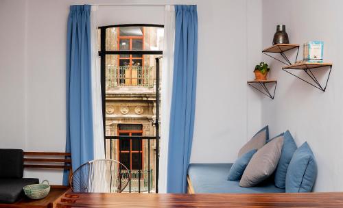a living room with a blue couch and a window at Casa Pepe in Mexico City