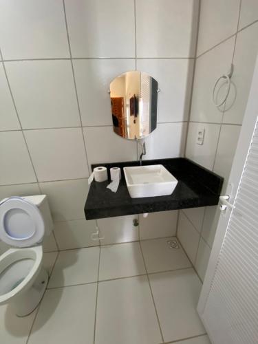 a small bathroom with a sink and a toilet at Chico do Caranguejo Praia da Baleia in Itapipoca