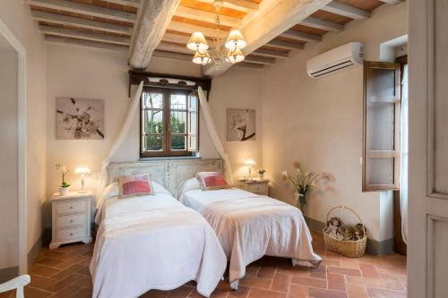two beds in a room with two windows at Torre La Ripa 8, Emma Villas in Cortona
