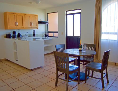 a kitchen and dining room with a table and chairs at Sunrock Hotel & Suites in Cabo San Lucas