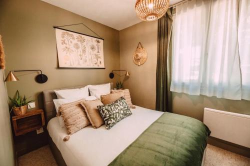 sypialnia z łóżkiem z poduszkami i oknem w obiekcie La Casa Bali w mieście Irigny