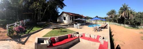 a house with a red couch in front of a yard at Chalés do Recanto in São João del Rei