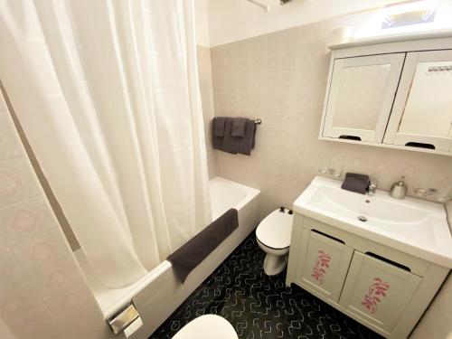 biała łazienka z umywalką i toaletą w obiekcie Sonnalpine Apt 12 - Managed by TheSelectionist w Sankt Moritz