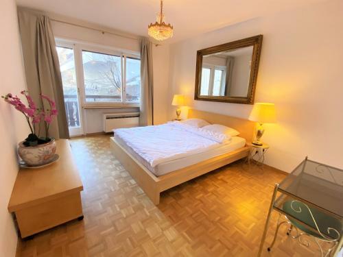 sypialnia z łóżkiem i lustrem na ścianie w obiekcie Sonnalpine Apt 12 - Managed by TheSelectionist w Sankt Moritz