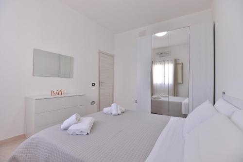 Un dormitorio blanco con una cama grande con toallas. en IzzHome Lagoon, en Pula