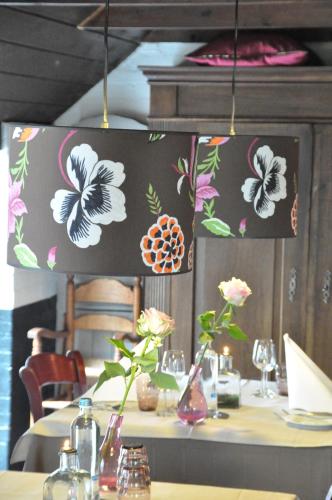 a table with vases and flowers on a wall at Hotel Boerderij Restaurant De Gloepe in Diffelen