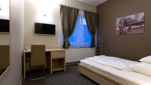 een slaapkamer met een bed en een bureau met een computer bij Varga-ház panzió in Budaörs