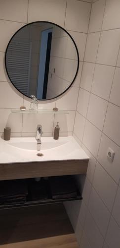a bathroom with a sink and a mirror at B&B de Wilhelminaschool in Aalten