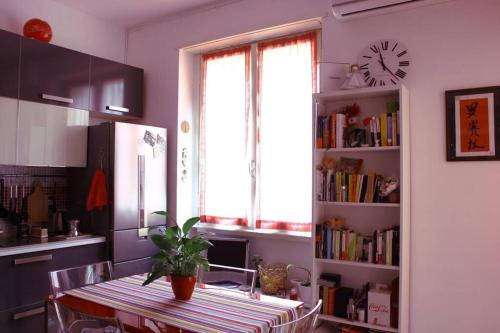 een keuken met een tafel en een klok aan de muur bij Comfortable Studio Flat by The Navigli in Milaan