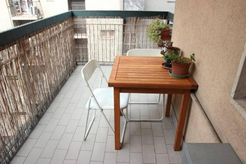 Comfortable Studio Flat by The Navigli في ميلانو: طاولة وكراسي خشبية على شرفة
