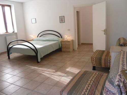 ein Schlafzimmer mit einem Bett und Fliesenboden in der Unterkunft Appartamenti Le Foci in Portoferraio