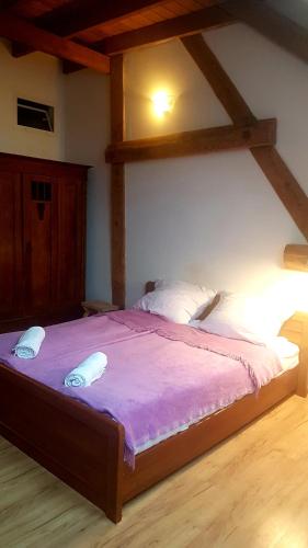 a bedroom with a large bed with a purple blanket at Dziewanna in Brzeziniec