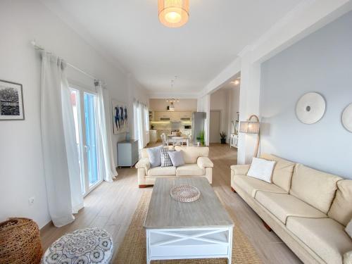 a living room with two couches and a table at Beautiful house by the sea in Poros