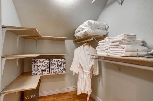 a closet with wooden shelves and white towels at Monument Retreat - Walk to Local Dining and Shopping in Monument
