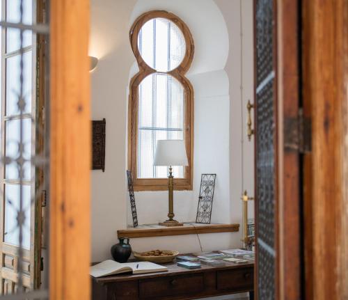 een kamer met een tafel met een lamp en een raam bij Casa Almara in Espejo
