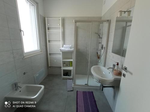 a bathroom with a sink, toilet and tub at AdagioRooms in Elmas