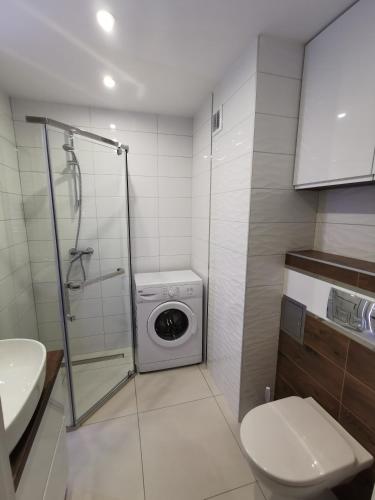 a bathroom with a washing machine and a washer at Apartament D&T City Center View in Rzeszów