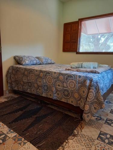 a large bed in a room with a window at Chalé Veredas e Buritis in Pirenópolis