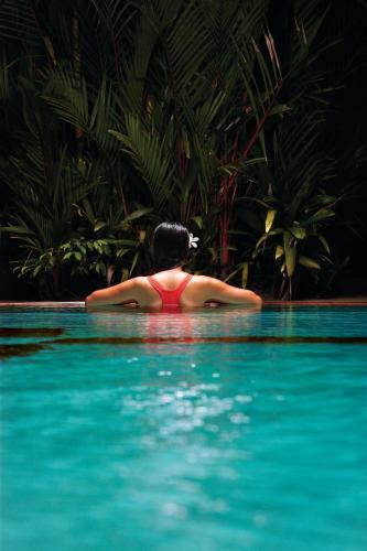 a woman in the water in a swimming pool at The Gateway Hotel Beach Road, Calicut in Kozhikode