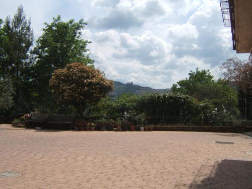 a brick courtyard with potted plants and trees at Greatview Narni in Narni