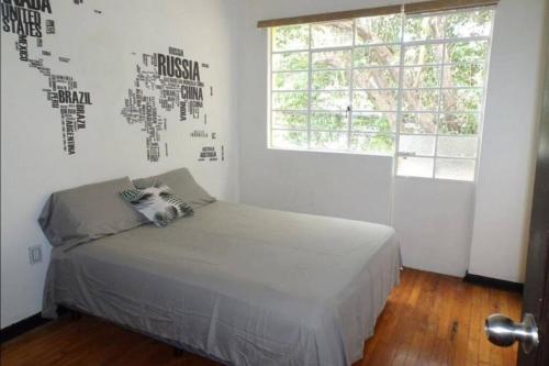 - une chambre avec un lit à baldaquin sur le mur dans l'établissement Apto Excelente ubicación., à Mexico