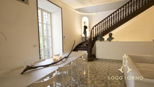 un salon avec une table et un escalier dans l'établissement Guest House A Via dei Pellegrini, à Viterbe