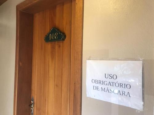 a sign on a door with a sign on it at Apartamentos Sulla Collina Centro de Gramado localizado próximo da rua Coberta in Gramado