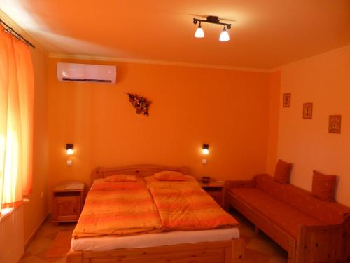 - une chambre avec un lit et un canapé dans l'établissement Napfény Apartman és Vendégház, à Egerszalók