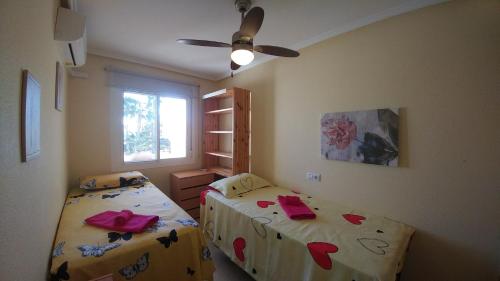 - une chambre avec 2 lits et un ventilateur de plafond dans l'établissement Casa Laurent, à Gran Alacant