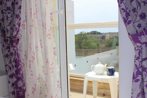 a room with a window and a table with a tea pot at Il-Qastna Holiday House in Żejtun