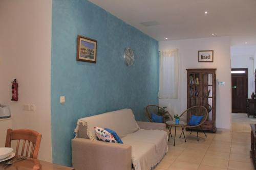 a living room with a couch and a blue wall at Il-Qastna Holiday House in Żejtun