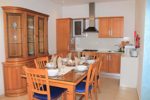 a kitchen with a dining room table and chairs at Il-Qastna Holiday House in Żejtun