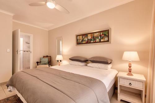 ein Schlafzimmer mit einem großen Bett und einem Gemälde an der Wand in der Unterkunft Perlemoen Retreat in Herolds Bay