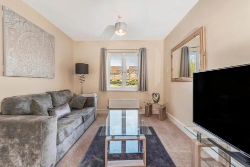 a living room with a couch and a flat screen tv at London Heathrow Living Holywell Serviced Houses - 3 and 4 bedrooms By Ferndale in Stanwell