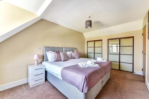 a bedroom with a large bed with a purple blanket at London Heathrow Living Holywell Serviced Houses - 3 and 4 bedrooms By Ferndale in Stanwell
